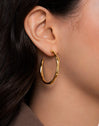 Bamboo Steel Gold-Plated Hoop Earrings - puesto en modelo